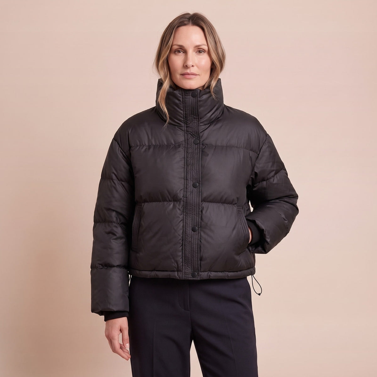 Kurze schwarze Pufferjacke mit Stehkragen und Druckknöpfen, geschlossen getragen