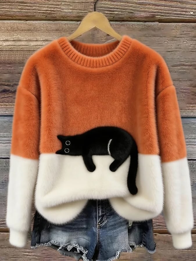 Orangefarbener Pullover mit Katzen-Print auf dem Kleiderbügel 1
