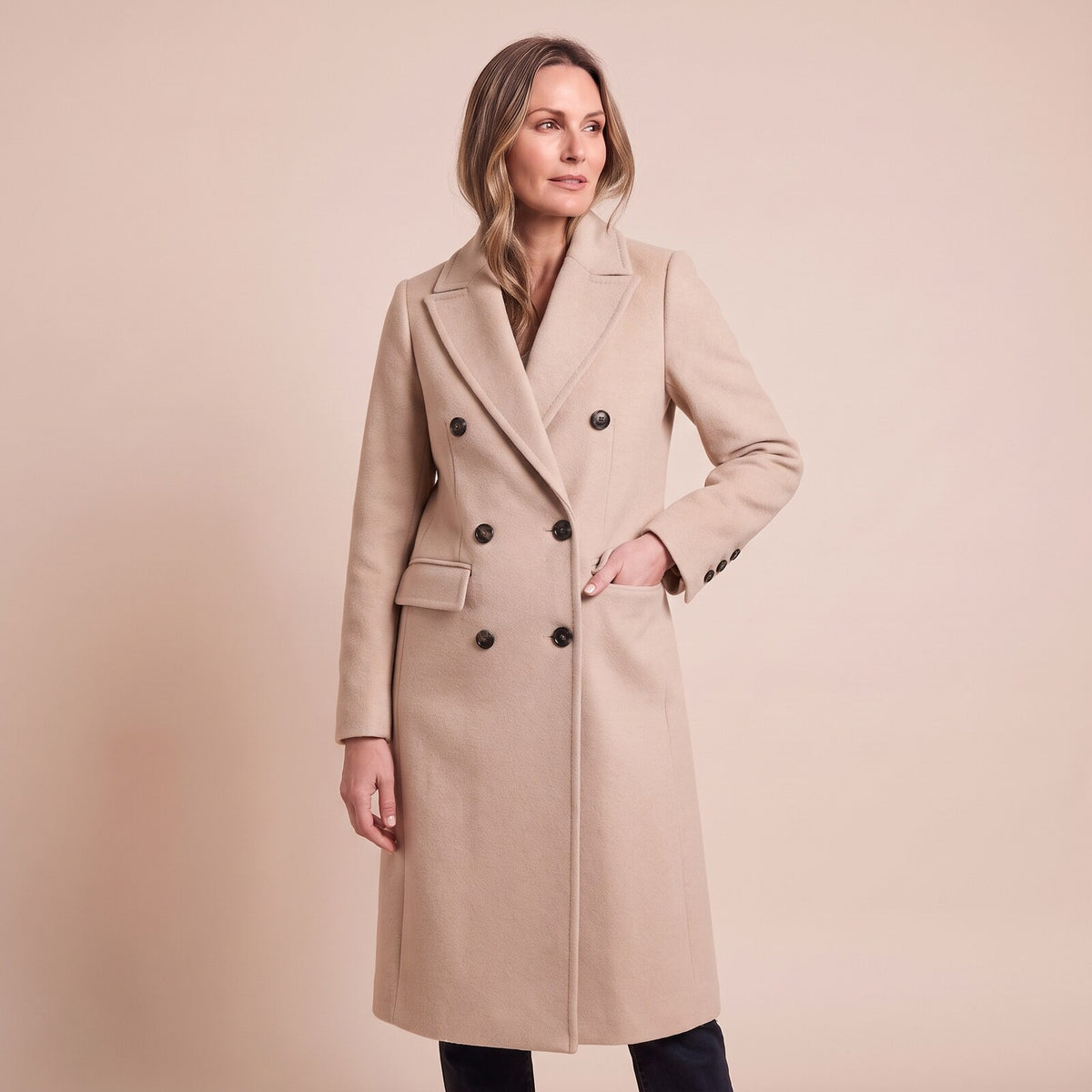 Model trägt den Mantel mit Reverskragen und Pattentaschen in Beige